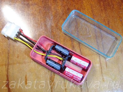 Электролитические конденсаторы с припаянным разъемом питания в небольшой пластмассовой коробочке.
