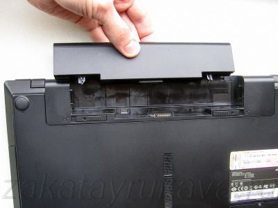 Отсоединение аккумулятора от ноутбука после разблокировки креплений.